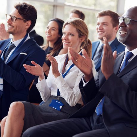 Smiling audience applauding at a business seminar